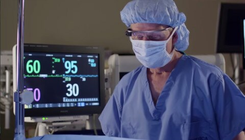 Anesthesiologist activating Google Glass by touching the glasses.